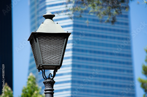 Streetlight of Madrid over a blue skyscraper during the day