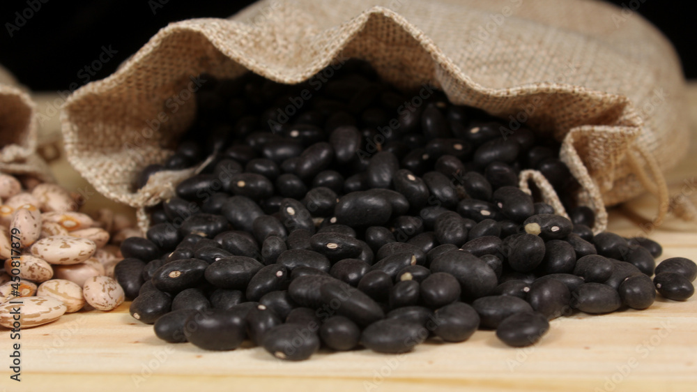 Dried Pinto Beans and Black Beans in Burlap Bag on Wooden Background Dried Pinto Beans and Black Beans in Burlap Bag on Wooden Background