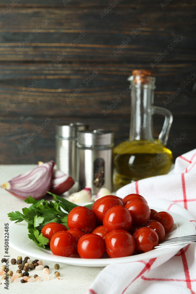 Concept of pickled vegetables with tomatoes on white textured table Concept of pickled vegetables with tomatoes on white textured table