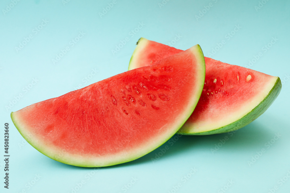Ripe watermelon slices on blue background, close up Ripe watermelon slices on blue background, close up