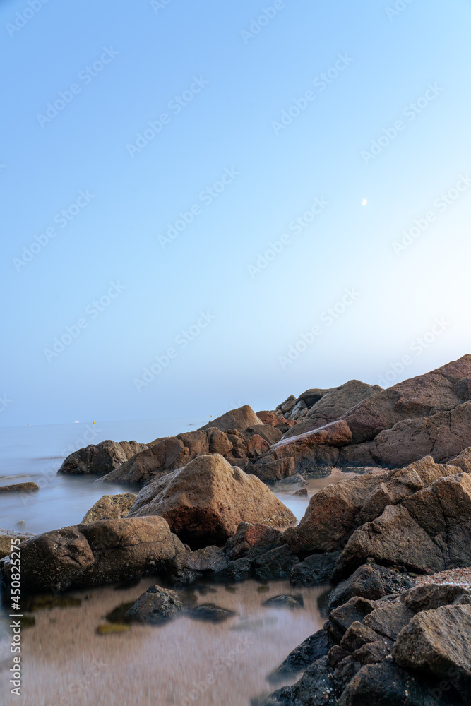 beach and rocks in sea in summer, costa brava, vertical photo