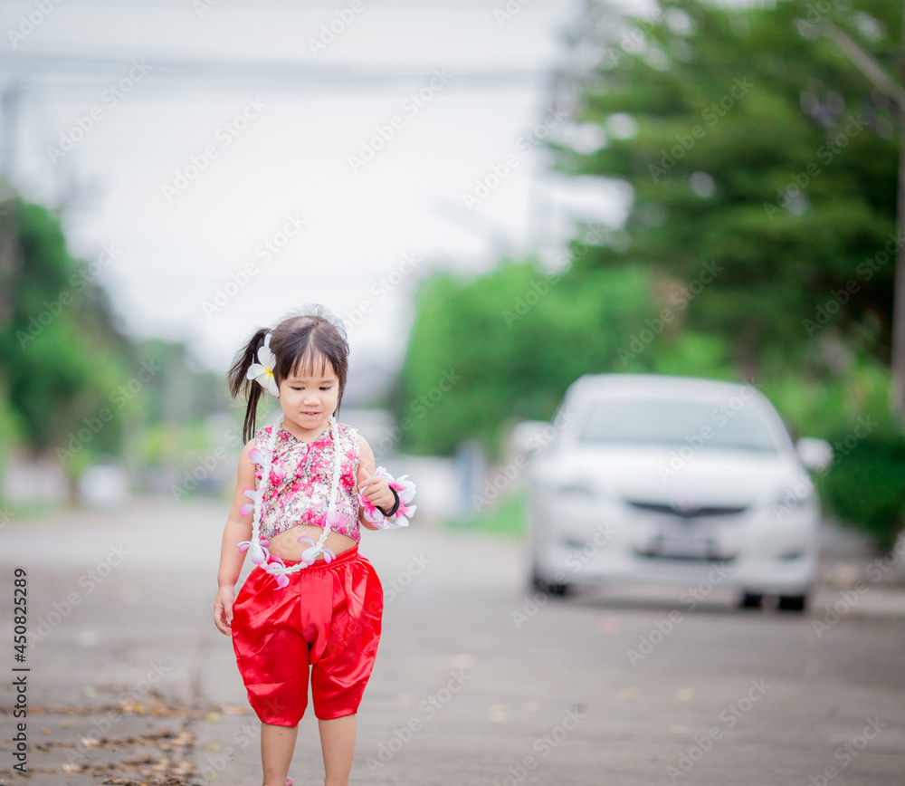 Close-up background view of a blurred Asian girl running or teasing in the street in front of the house, doing activities together outside the classroom during the holidays. Close-up background view of a blurred Asian girl running or teasing in the street in front of the house, doing activities together outside the classroom during the holidays.