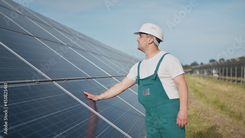 Assistance technical worker in uniform is checking an operation and efficiency performance of photovoltaic solar panels. Engineer repair and maintenance photovoltaic. Green energy project is going on. © GRAFStock
