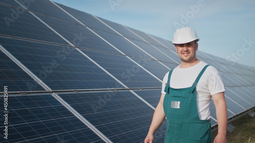 Assistance technical worker in uniform is checking an operation and efficiency performance of photovoltaic solar panels. Engineer repair and maintenance photovoltaic. Green energy project is going on.
