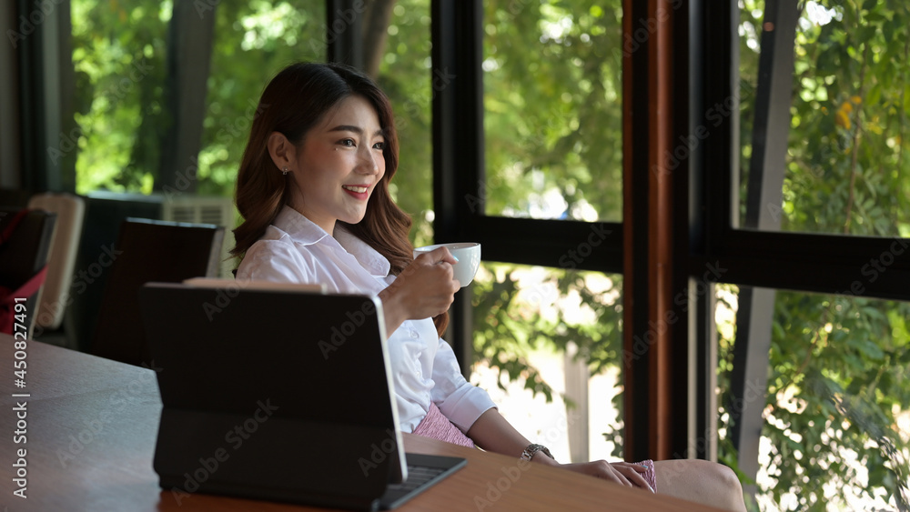 Portrait with businesswoman sitting in front of digital tablet and enjoy with coffee at office desk, coffee break, relaxing after work. Portrait with businesswoman sitting in front of digital tablet and enjoy with coffee at office desk, coffee break, relaxing after work.