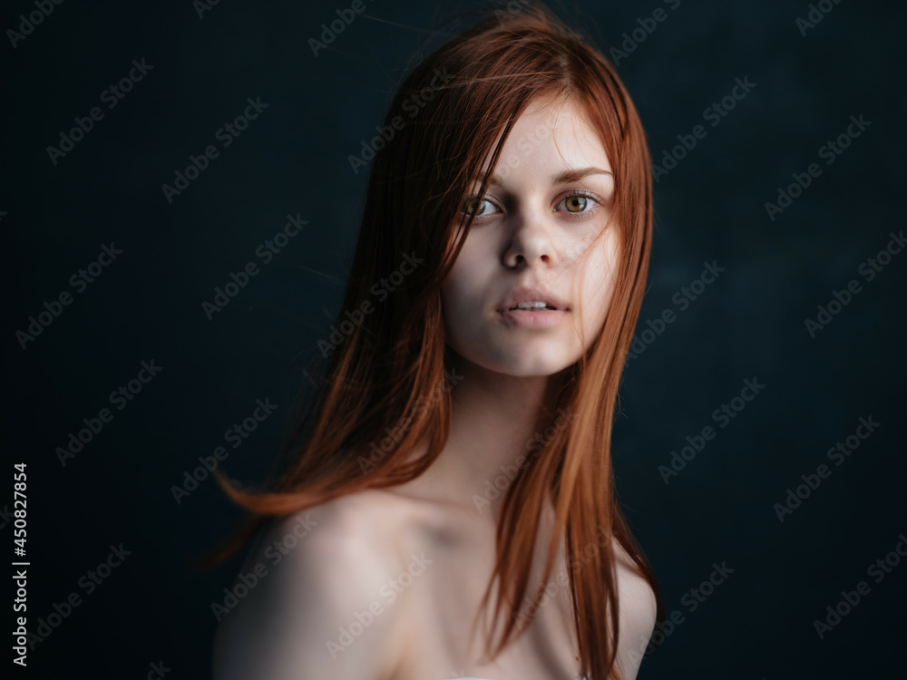 attractive red-haired woman naked shoulders clear skin dark background attractive red-haired woman naked shoulders clear skin dark background