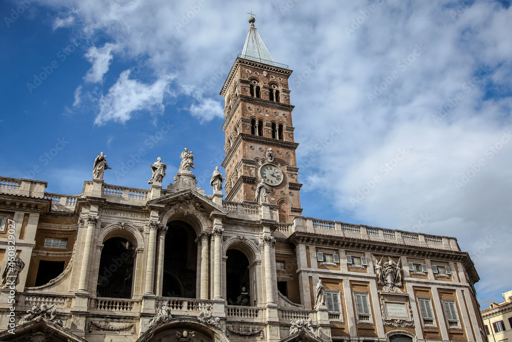 The bell tower of The Basilica of Saint Mary Major (Italian: Basilica di Santa Maria Maggiore) in Rome, against the background of a blue cloudy sky