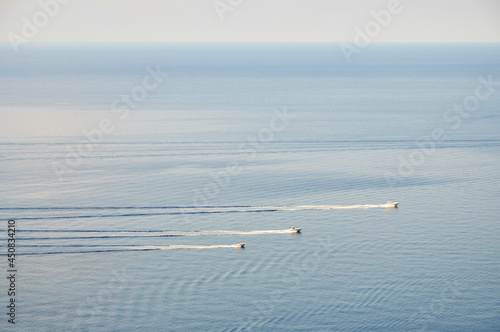 Recreational motor boats sailing fast together in a clear day with calm sea (Formentor peninsula, Majorca, Balearic Islands, Mediterranean sea, Spain)