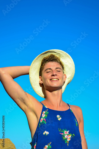 Beautiful young woman in a dress sitting by the sea in Spain.