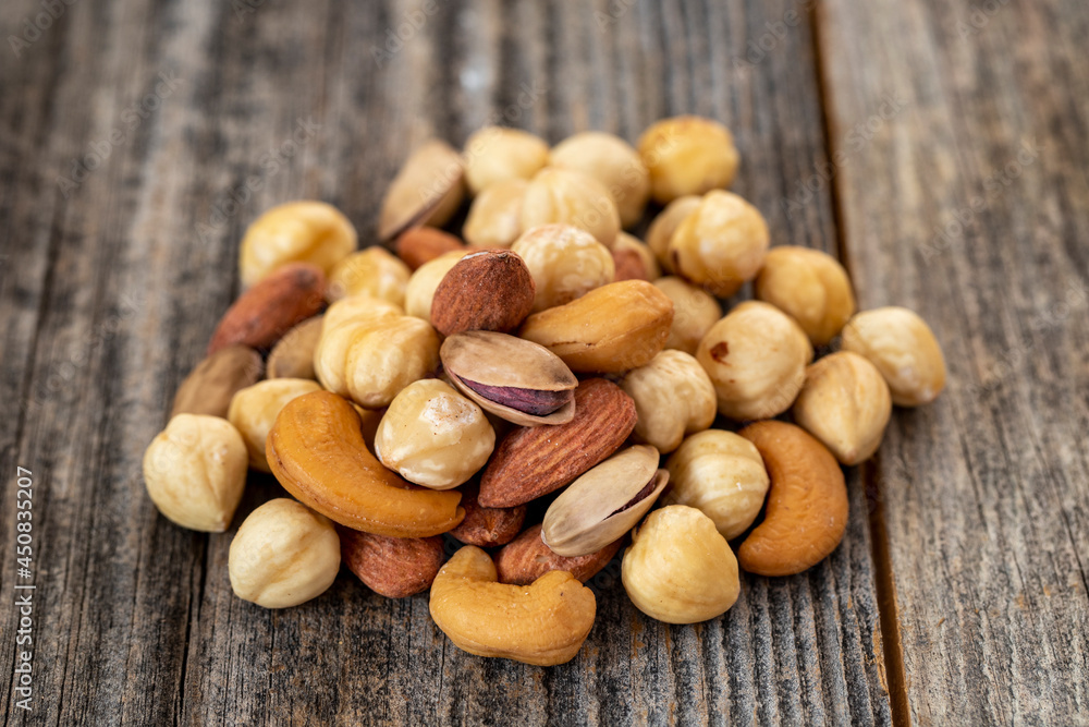 Mixed nuts on wood floor. Organic and fresh nuts. close up Mixed nuts on wood floor. Organic and fresh nuts. close up