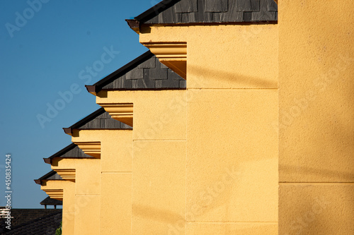 Series of yellow houses with black slate roofs