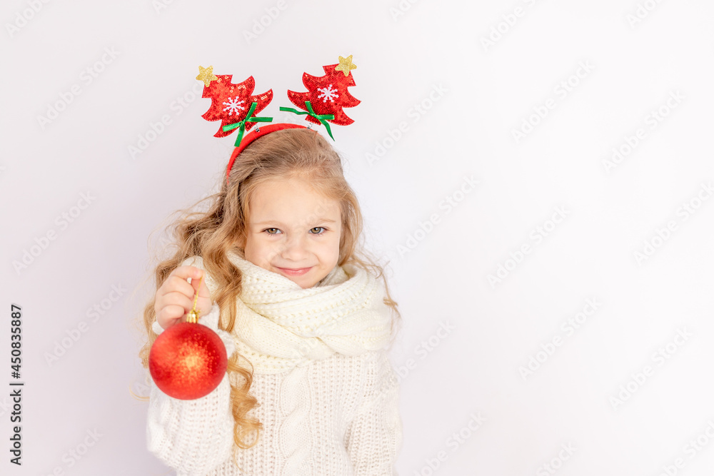 baby girl holding a red Christmas ball on a white isolated background, space for text baby girl holding a red Christmas ball on a white isolated background, space for text