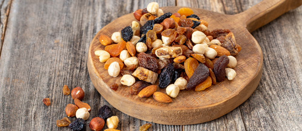 Mixed nuts on wood floor. Organic and fresh nuts. Wooden spoon on top of nuts. Copy space Mixed nuts on wood floor. Organic and fresh nuts. Wooden spoon on top of nuts. Copy space