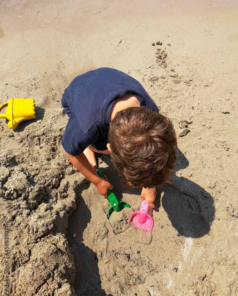 Summer Children Activities on Beach. Child play with sand.
