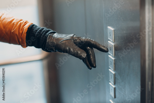 Close up of forefinger pressing the button elevator during coronavirus pandemic covid-19