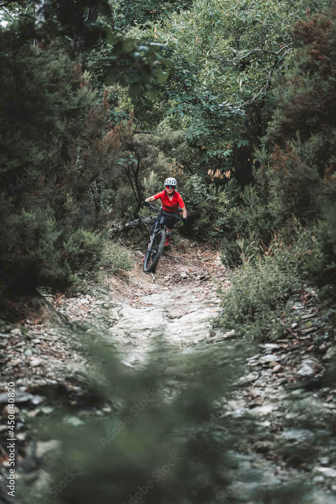 Medium close shot of female mountainbiker on rocky trail Medium close shot of female mountainbiker on rocky trail