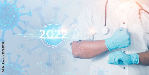 2022 health insurance concept. Doctor or scientist with stethoscope in hand with syringe vaccine showing health insurance related icons on virtual screen. 