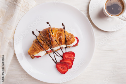 Top view on a plate with croissant sandwich with whipped cream. photo