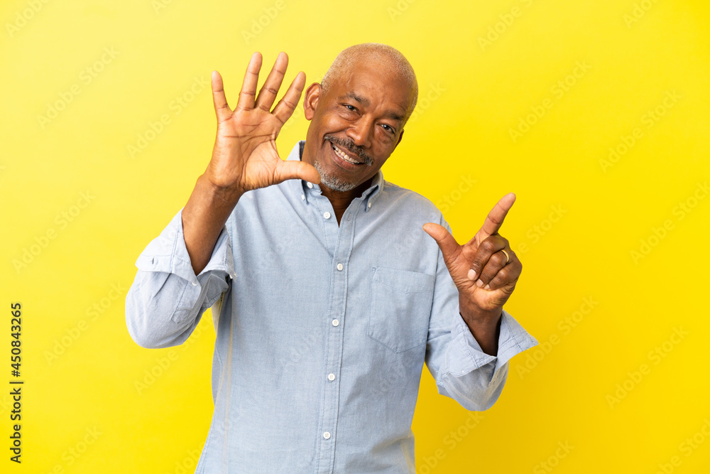 Cuban Senior isolated on yellow background counting seven with fingers Cuban Senior isolated on yellow background counting seven with fingers