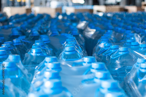 Blue five-liter plastic water bottles packed at the warehouse of finished products