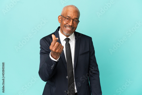 Business senior man isolated on blue background making money gesture