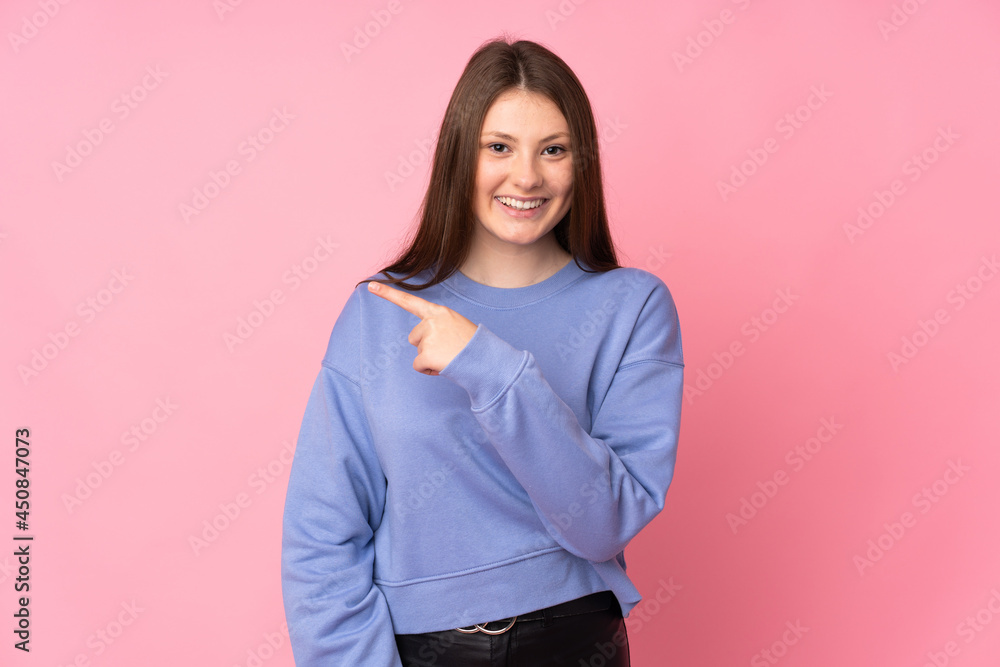 Teenager caucasian girl isolated on pink background pointing to the side to present a product Teenager caucasian girl isolated on pink background pointing to the side to present a product