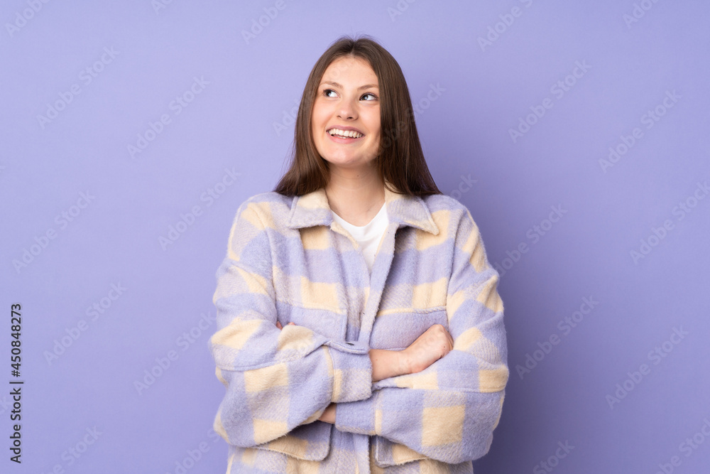 Teenager caucasian girl isolated on purple background looking up while smiling Teenager caucasian girl isolated on purple background looking up while smiling
