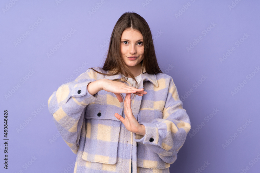 Teenager caucasian girl isolated on purple background making time out gesture Teenager caucasian girl isolated on purple background making time out gesture