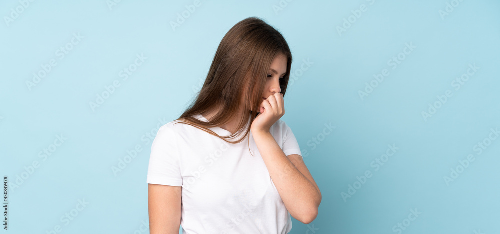 Teenager caucasian girl isolated on blue background having doubts Teenager caucasian girl isolated on blue background having doubts
