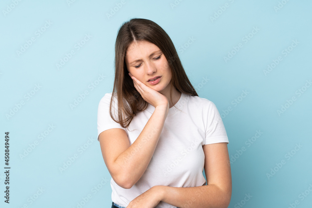 Teenager caucasian girl isolated on blue background with toothache Teenager caucasian girl isolated on blue background with toothache