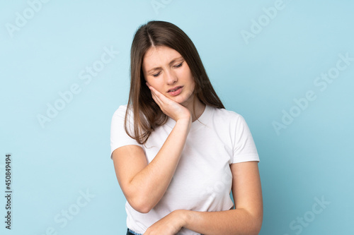 Teenager caucasian girl isolated on blue background with toothache