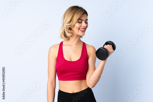 Teenager Russian girl making weightlifting isolated on blue background with happy expression