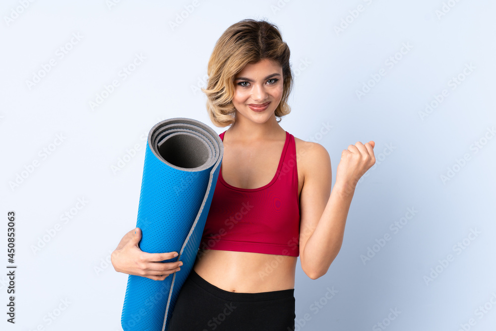 Russian girl with mat isolated on blue background and pointing it Russian girl with mat isolated on blue background and pointing it