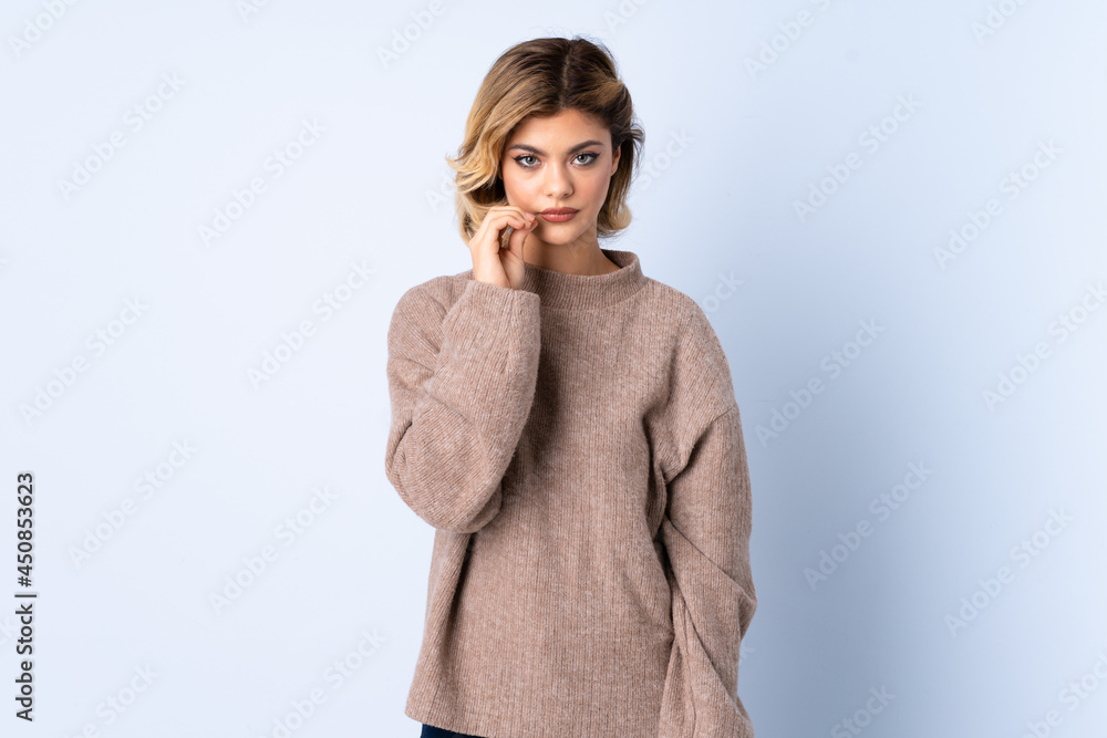 Young Russian woman isolated on blue background showing a sign of silence gesture Young Russian woman isolated on blue background showing a sign of silence gesture