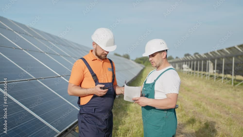 Chief engineer and specialists learning the report of investment for solar plant construction. Business team. Negotiation. Clean energy. Industry. Engineers installing new sunny batteries. Chief engineer and specialists learning the report of investment for solar plant construction. Business team. Negotiation. Clean energy. Industry. Engineers installing new sunny batteries.