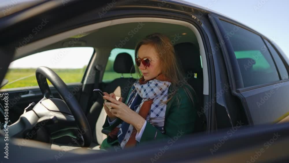 Woman sitting in car and using mobile phone. Woman sitting in car and using mobile phone.