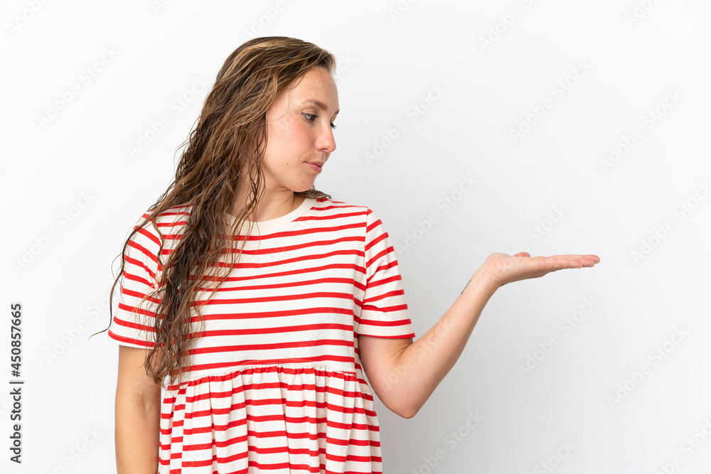 Young caucasian woman isolated on white background holding copyspace with doubts Young caucasian woman isolated on white background holding copyspace with doubts
