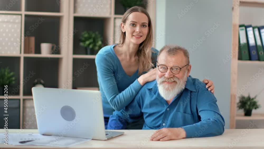 Happy grandfather father and granddaughter daughter hugging posing together at modern workplace