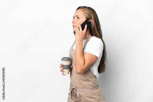 Restaurant waiter caucasian woman isolated on white background holding coffee to take away and a mobile