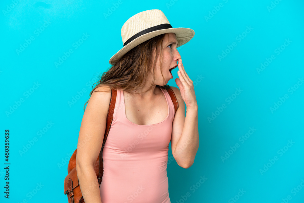 Young caucasian woman in summer holidays isolated on blue background yawning and covering wide open mouth with hand Young caucasian woman in summer holidays isolated on blue background yawning and covering wide open mouth with hand