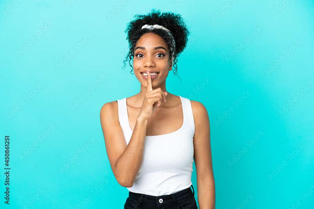 Young latin woman isolated on blue background showing a sign of silence gesture putting finger in mouth Young latin woman isolated on blue background showing a sign of silence gesture putting finger in mouth