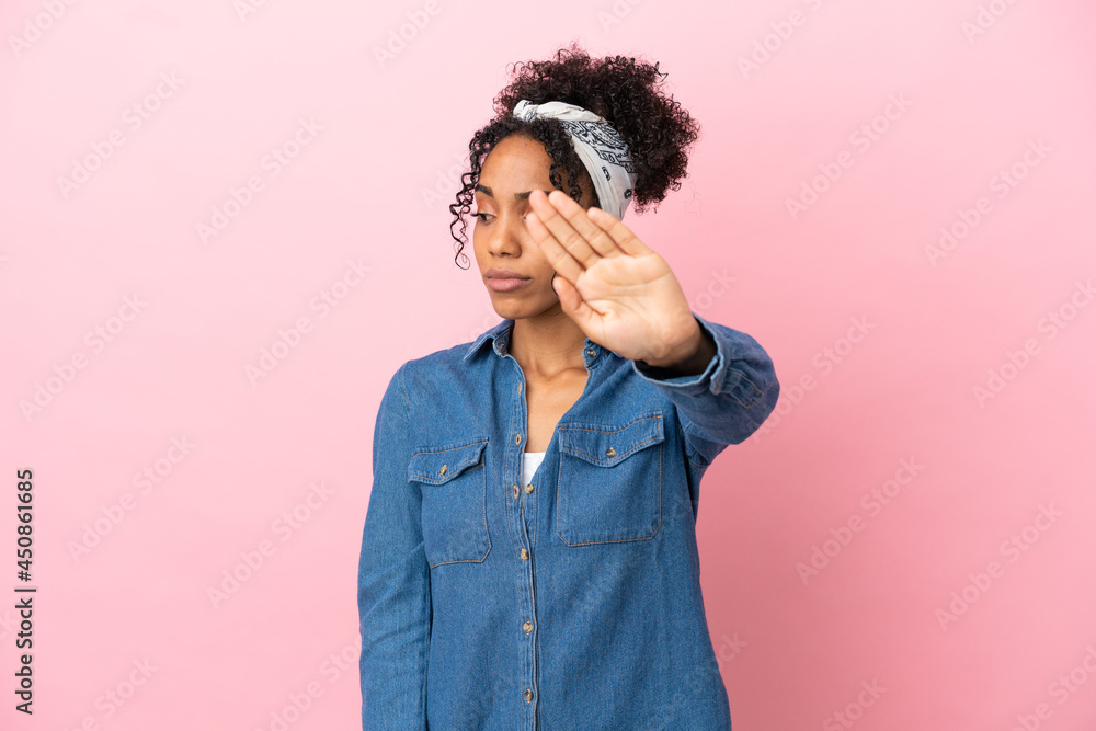 Young latin woman isolated on pink background making stop gesture and disappointed Young latin woman isolated on pink background making stop gesture and disappointed