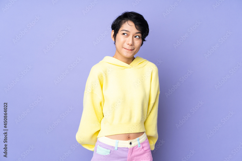 Young Vietnamese woman with short hair over isolated purple background having doubts while looking up Young Vietnamese woman with short hair over isolated purple background having doubts while looking up