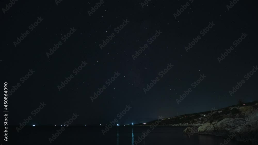 Moving night starry sky. Starry night over sea coast time-lapse. Passing by cars light trails in the night. Moving night starry sky. Starry night over sea coast time-lapse. Passing by cars light trails in the night.