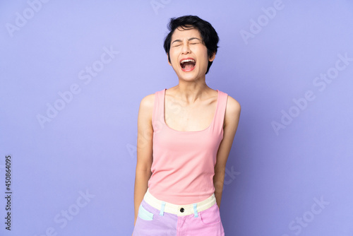Young Vietnamese woman with short hair over isolated purple background shouting to the front with mouth wide open