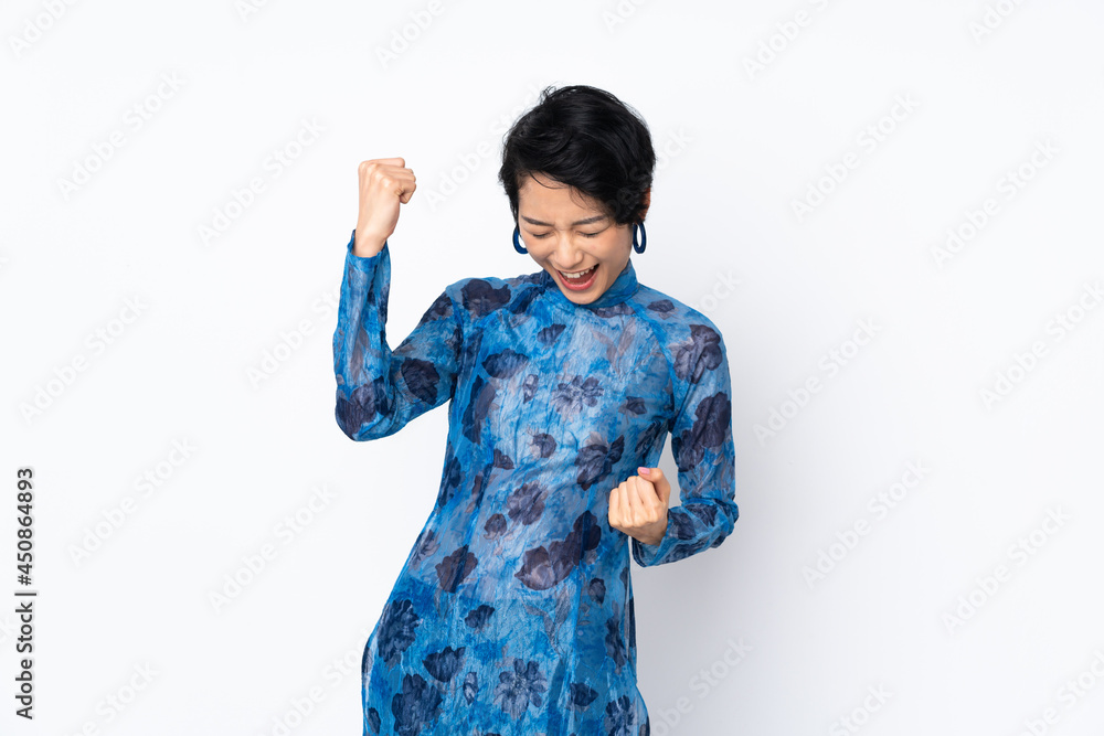 Young Vietnamese woman with short hair wearing a traditional dress over isolated white background celebrating a victory Young Vietnamese woman with short hair wearing a traditional dress over isolated white background celebrating a victory
