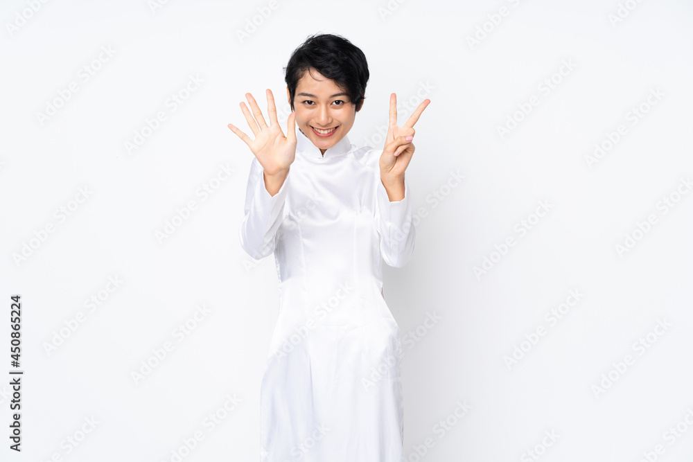 Young Vietnamese woman with short hair wearing a traditional dress over isolated white background counting seven with fingers Young Vietnamese woman with short hair wearing a traditional dress over isolated white background counting seven with fingers