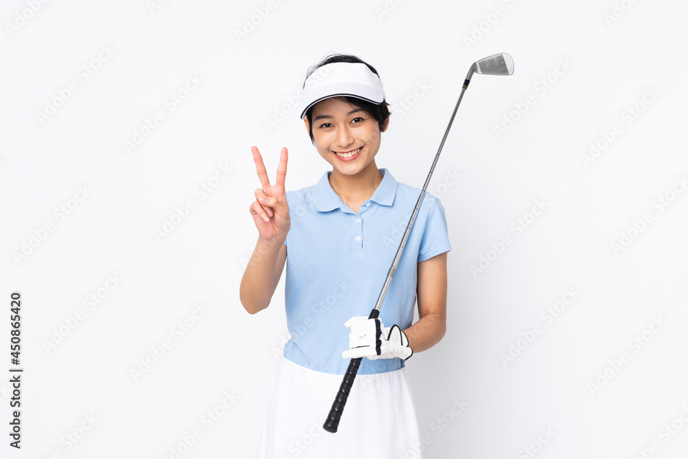 Young Vietnamese golfer woman over isolated white wall smiling and showing victory sign Young Vietnamese golfer woman over isolated white wall smiling and showing victory sign