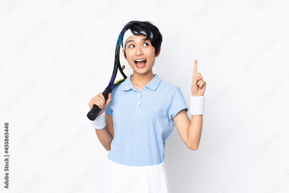 Young Vietnamese tennis player woman over isolated white wall playing tennis and pointing up Young Vietnamese tennis player woman over isolated white wall playing tennis and pointing up