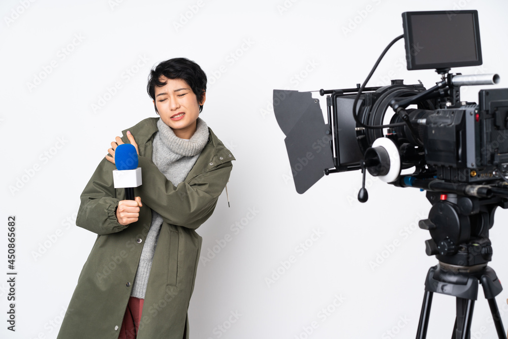 Reporter Vietnamese woman holding a microphone and reporting news suffering from pain in shoulder for having made an effort